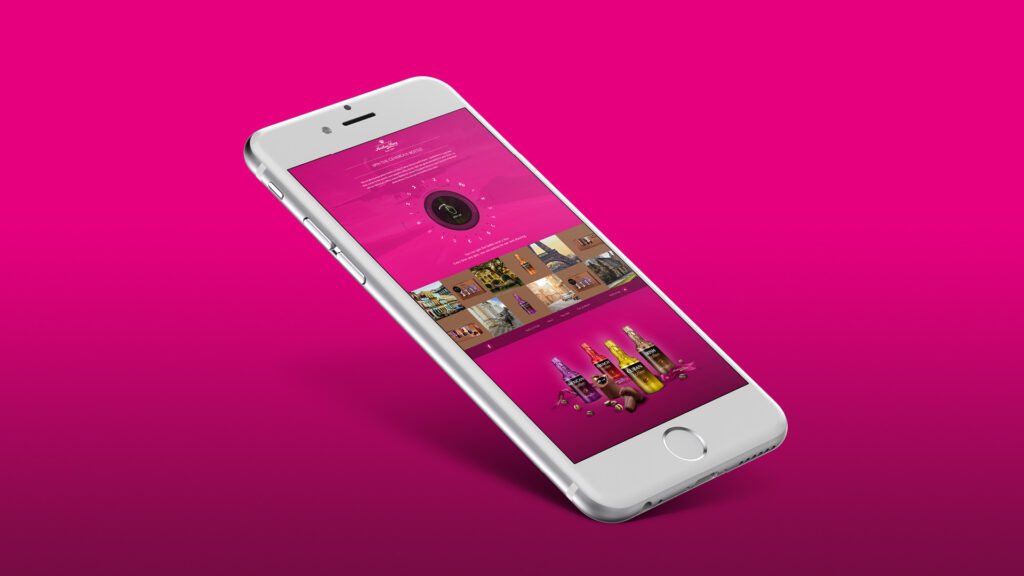 billede af iPhone med screenshot af Anthon Berg Spin the bottle app på lyserød baggrund